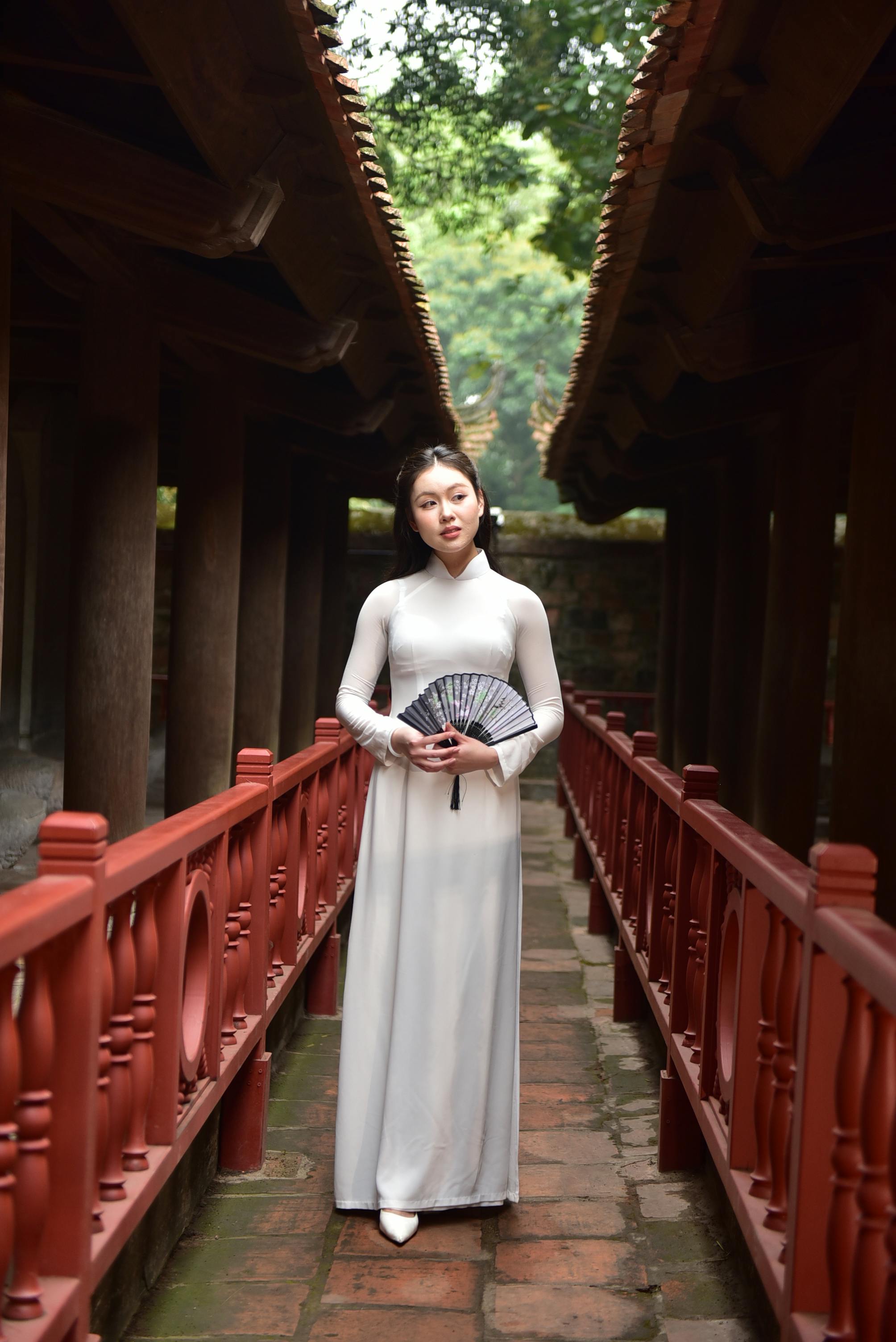 美景图片HD_身着传统奥黛、手持扇子的优雅女子